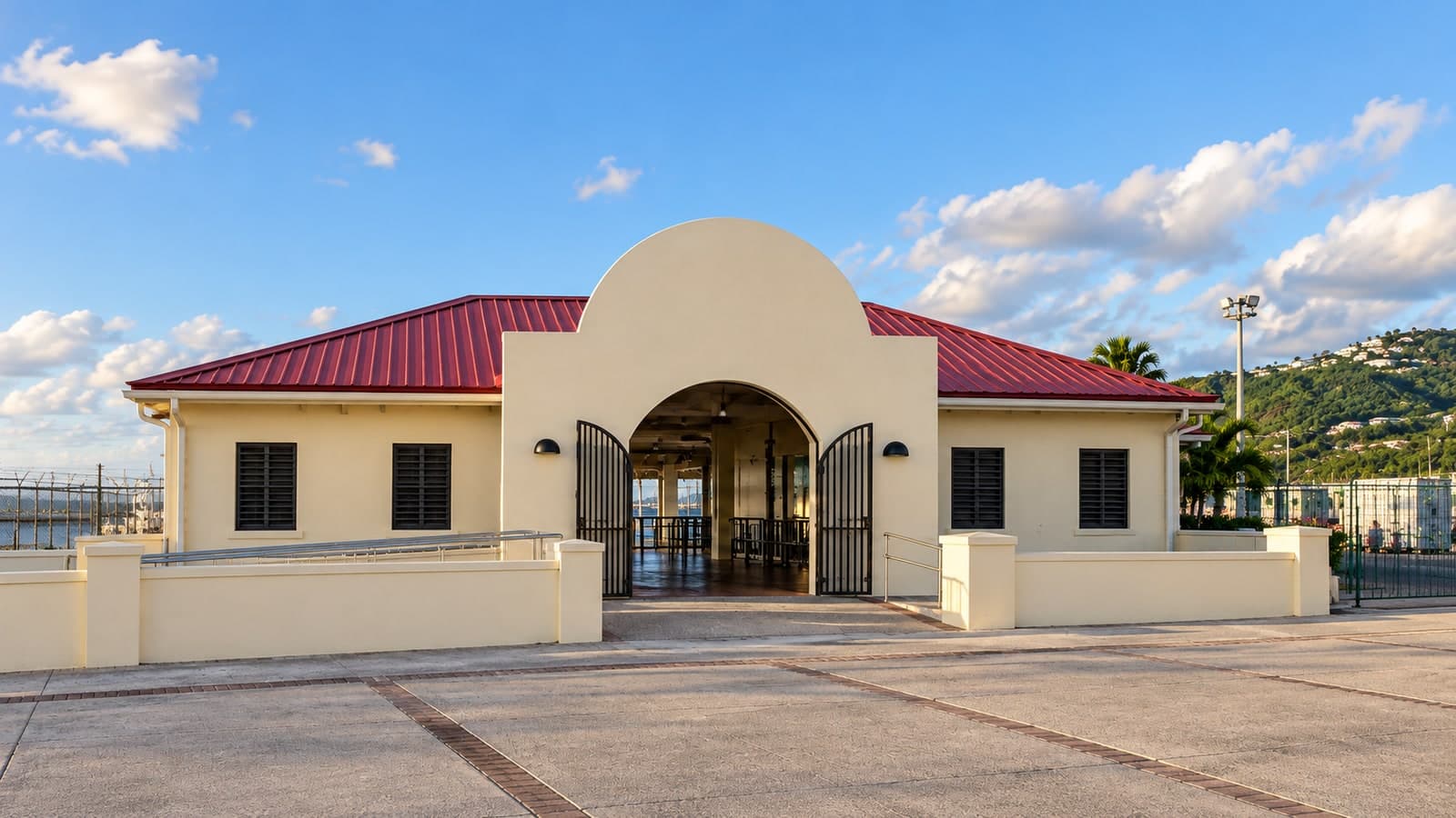 Illustration of a cream marine terminal entrance with a rounded arch, red roof and iron gates.